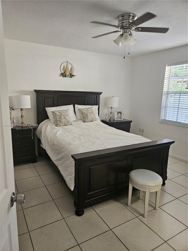 bedroom with light tile patterned floors, ceiling fan, and a textured ceiling