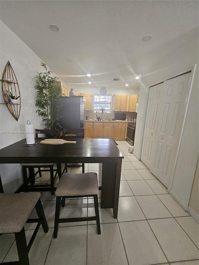 dining space with light tile patterned floors and recessed lighting