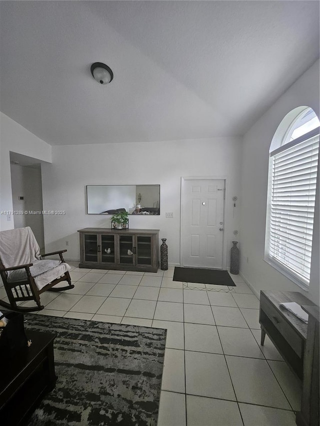 interior space with a wealth of natural light, light tile patterned flooring, and lofted ceiling