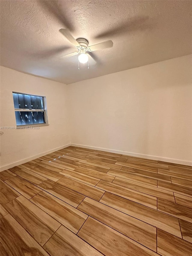 249 SW 4th Ct, Homestead, FL 33030 - spare room with wood tiled floors, a ceiling fan, a textured ceiling, and baseboards