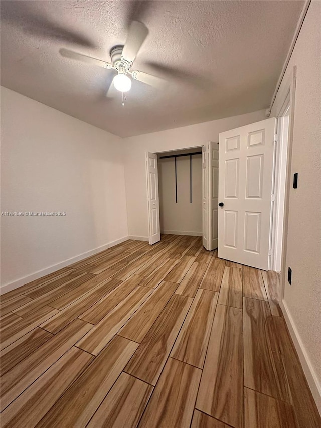 249 SW 4th Ct, Homestead, FL 33030 - unfurnished bedroom with light wood-style floors, a textured ceiling, a closet, a ceiling fan, and baseboards