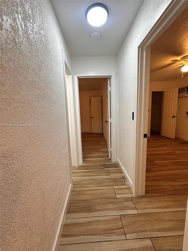 249 SW 4th Ct, Homestead, FL 33030 - hallway featuring a textured wall, wood tiled floors, and baseboards