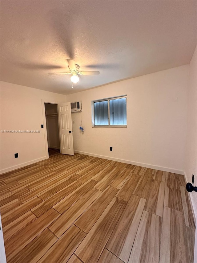 249 SW 4th Ct, Homestead, FL 33030 - unfurnished room featuring an AC wall unit, wood finish floors, a ceiling fan, baseboards, and a textured ceiling