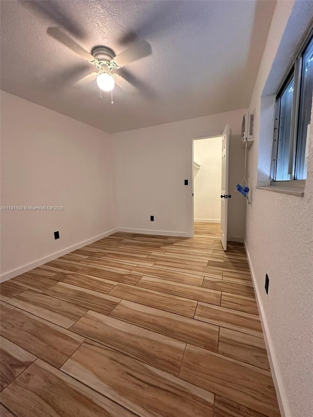 249 SW 4th Ct, Homestead, FL 33030 - empty room with wood tiled floors, a ceiling fan, a textured ceiling, and baseboards