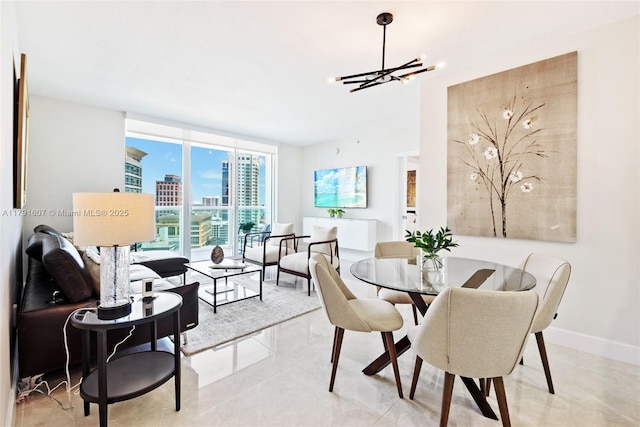 dining room with baseboards, a wall of windows, a notable chandelier, and a city view