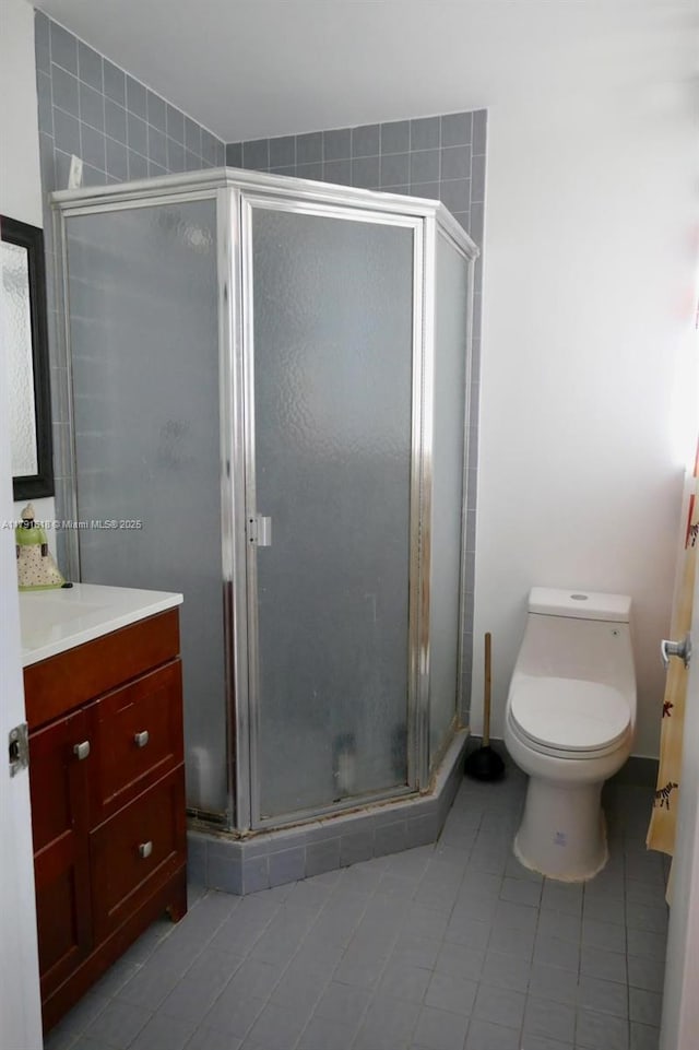 full bathroom with tile patterned floors, a shower stall, toilet, and vanity