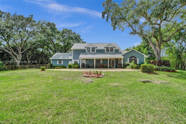 rear view of property with a yard, fence, and a porch