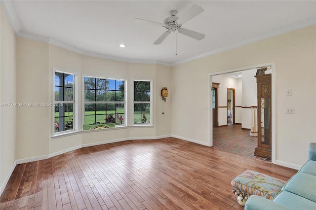 unfurnished living room with wood-type flooring, baseboards, and ornamental molding