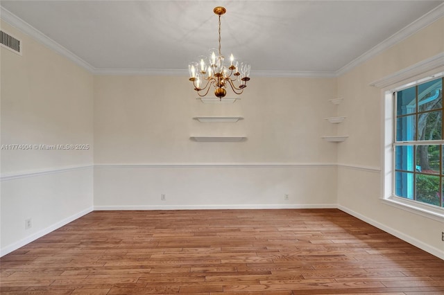 empty room featuring crown molding, baseboards, an inviting chandelier, and hardwood / wood-style flooring