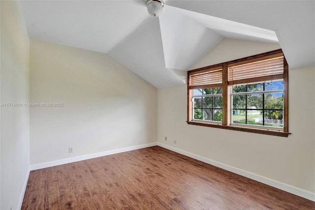 additional living space featuring baseboards, ceiling fan, wood finished floors, and lofted ceiling
