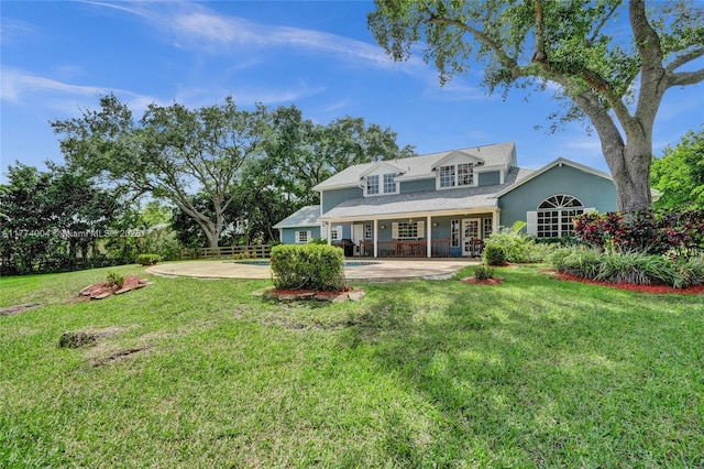 rear view of property featuring a yard, fence, french doors, and stucco siding