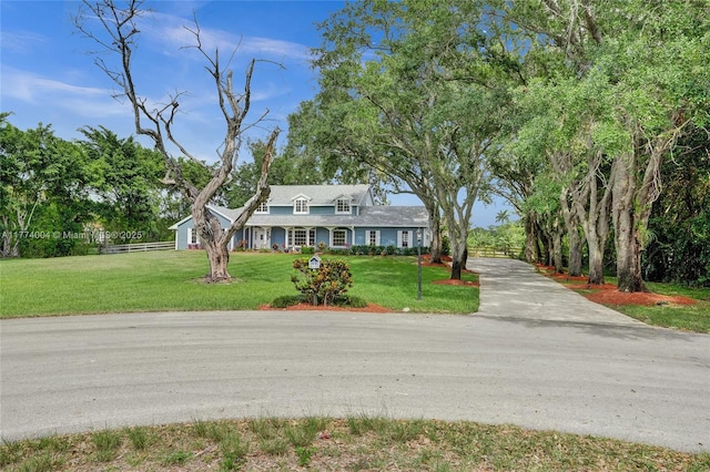 view of front of property with fence, driveway, and a front yard