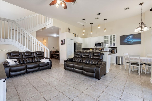 13119 SW 29th St, Miramar, FL 33027 - living room with light tile patterned floors, a high ceiling, stairway, a ceiling fan, and a chandelier