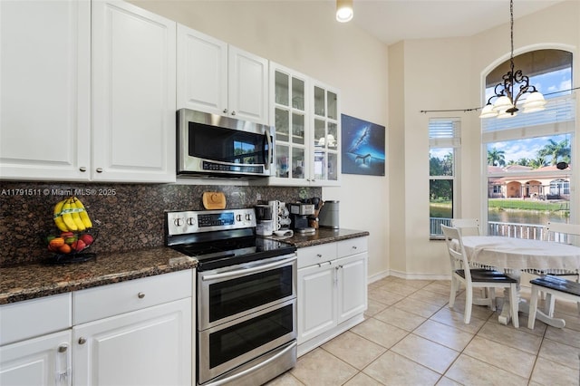 13119 SW 29th St, Miramar, FL 33027 - kitchen featuring appliances with stainless steel finishes, a chandelier, tasteful backsplash, white cabinetry, and glass insert cabinets