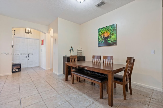 13119 SW 29th St, Miramar, FL 33027 - dining space with arched walkways, light tile patterned floors, and a textured ceiling