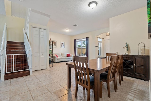13119 SW 29th St, Miramar, FL 33027 - dining area featuring arched walkways, stairs, a textured ceiling, and light tile patterned floors