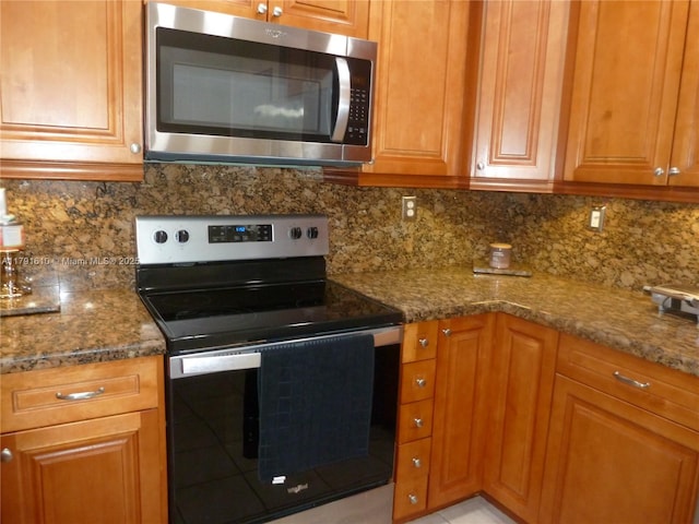 kitchen featuring stainless steel microwave, electric stove, brown cabinetry, and tasteful backsplash