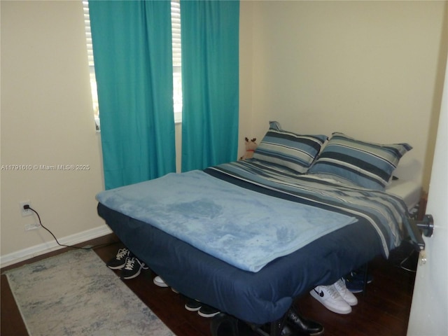 bedroom featuring wood finished floors and baseboards