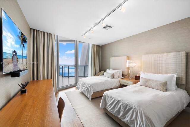 17121 Collins Ave Unit Ph4806, Sunny Isles Beach, FL 33160 - bedroom with rail lighting, access to outside, wood finished floors, wallpapered walls, and a water view