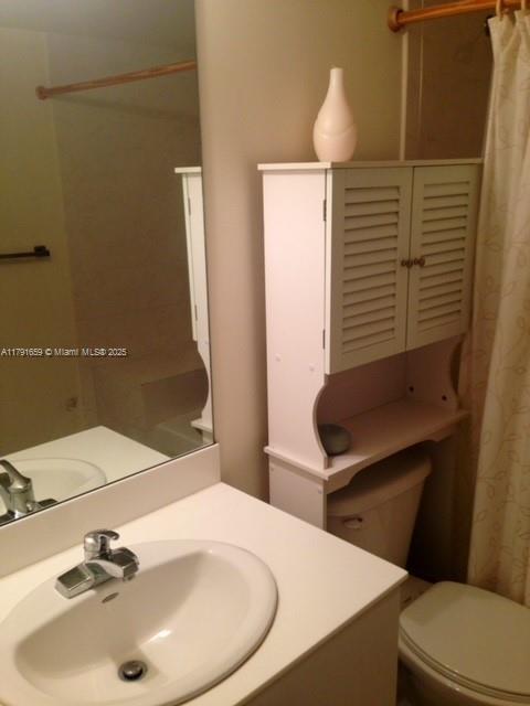 bathroom with toilet, a shower with curtain, and vanity