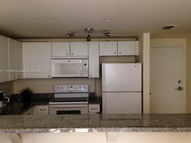 kitchen featuring white cabinetry, white appliances, and visible vents