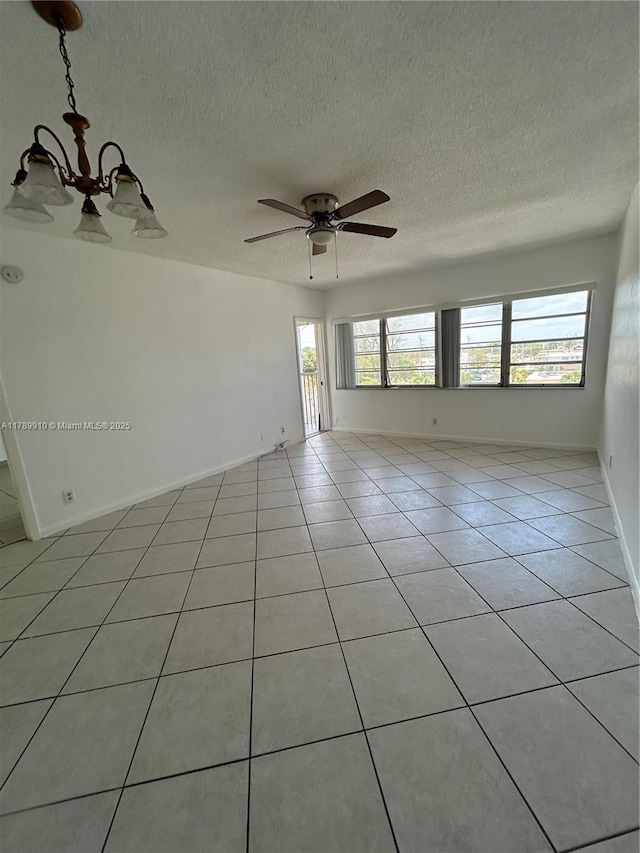 330 SE 2nd St Unit 404G, Hallandale Beach, FL 33009 - spare room featuring light tile patterned flooring, a textured ceiling, baseboards, and ceiling fan with notable chandelier