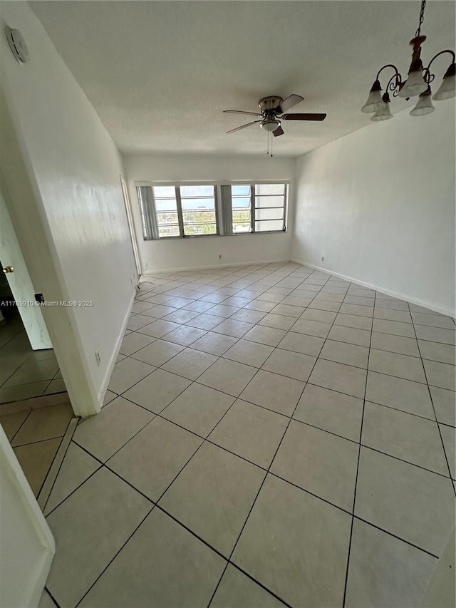330 SE 2nd St Unit 404G, Hallandale Beach, FL 33009 - empty room with light tile patterned floors, baseboards, and ceiling fan with notable chandelier