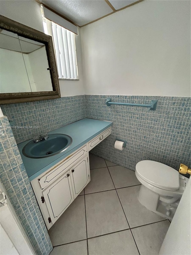 330 SE 2nd St Unit 404G, Hallandale Beach, FL 33009 - bathroom with toilet, tile walls, tile patterned floors, vanity, and wainscoting