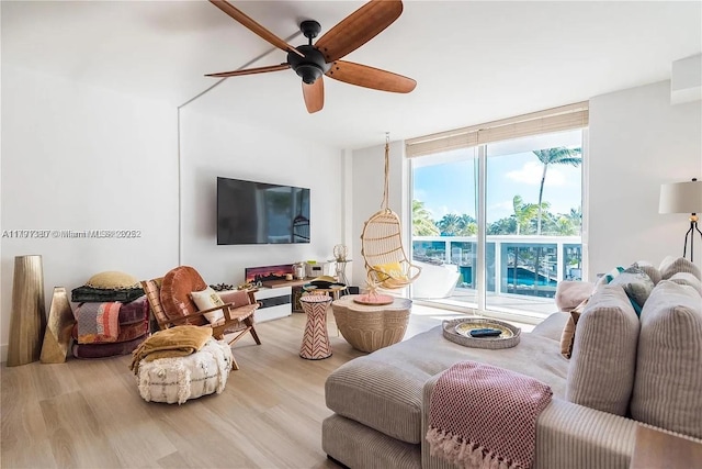 10275 Collins Ave Unit 219, Bal Harbour, FL 33154 - living area featuring floor to ceiling windows, wood finished floors, and a ceiling fan