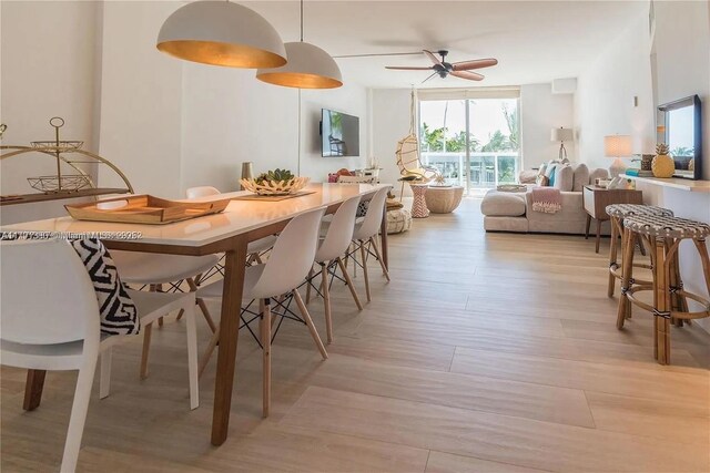 10275 Collins Ave Unit 219, Bal Harbour, FL 33154 - dining space featuring a wall of windows, ceiling fan, and light wood-style flooring