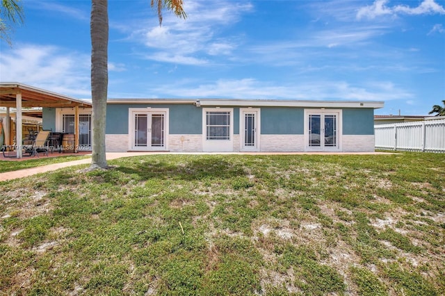 17501 NW 85th Ave, Hialeah, FL 33015 - back of property with fence, french doors, stucco siding, and a lawn