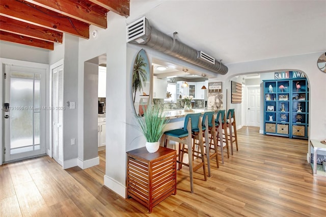 17501 NW 85th Ave, Hialeah, FL 33015 - dining room featuring light wood-style floors, arched walkways, and beamed ceiling