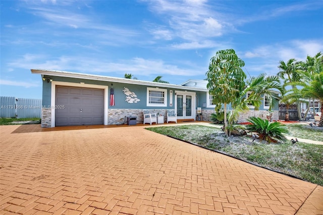 17501 NW 85th Ave, Hialeah, FL 33015 - single story home with french doors, stone siding, decorative driveway, an attached garage, and stucco siding