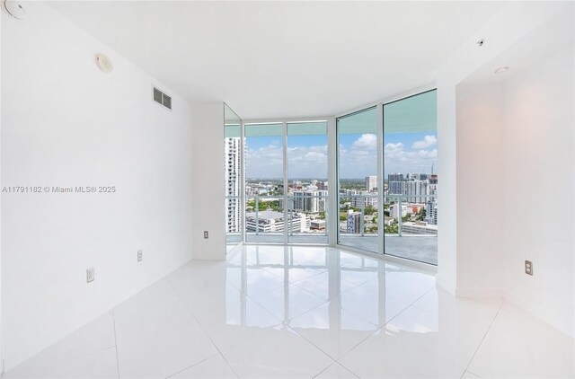 1900 N Bayshore Dr Unit 2816, Miami, FL 33132 - spare room with a wall of windows, a city view, tile patterned floors, a smoke detector, and baseboards