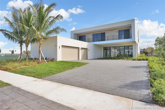16512 Botaniko Dr S, Weston, FL 33326 - contemporary house featuring an attached garage, decorative driveway, and stucco siding