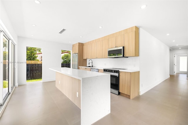 701 NE 119th St, Biscayne Park, FL 33161 - kitchen with stainless steel appliances, modern cabinets, light brown cabinetry, light countertops, and recessed lighting