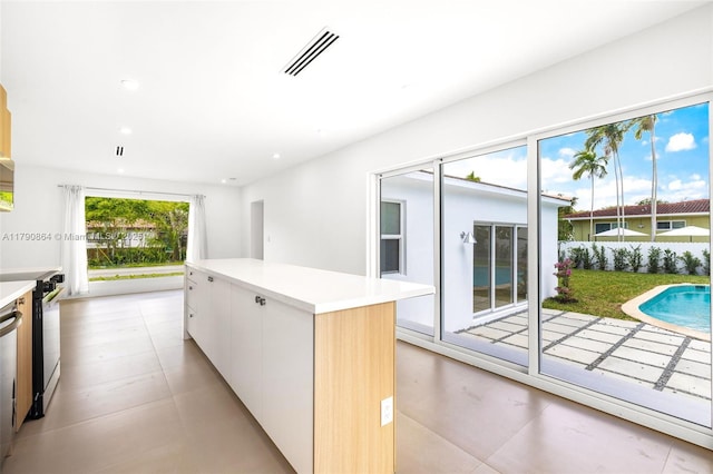 701 NE 119th St, Biscayne Park, FL 33161 - kitchen featuring white cabinetry, modern cabinets, light countertops, a kitchen island, and recessed lighting