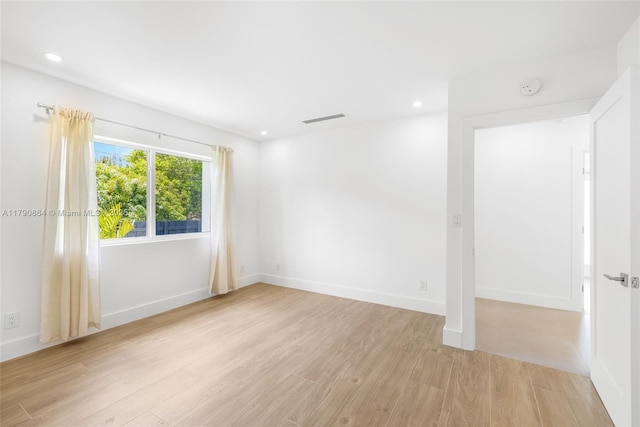 701 NE 119th St, Biscayne Park, FL 33161 - empty room featuring light wood finished floors, recessed lighting, a smoke detector, and baseboards