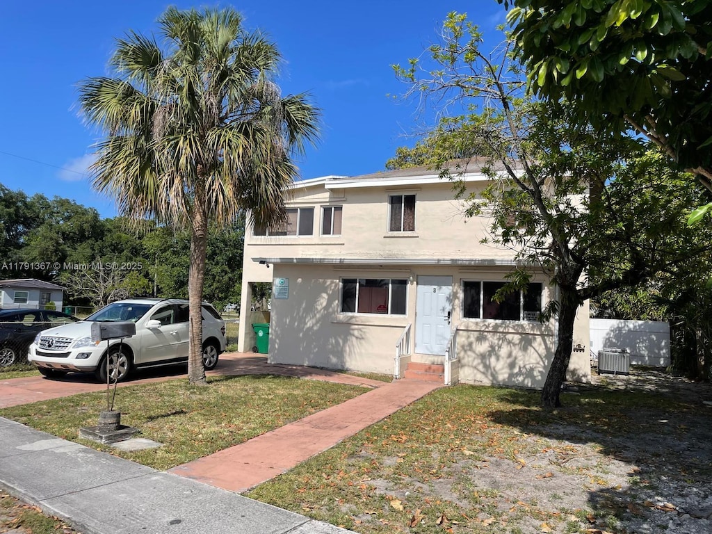 view of front of house with a front lawn, entry steps, stucco siding, and central air condition unit
