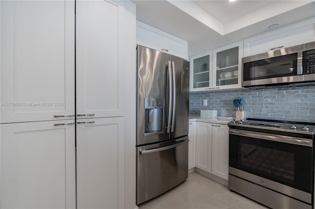 kitchen with white cabinetry, stainless steel appliances, and glass insert cabinets