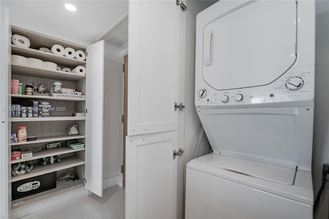 washroom with recessed lighting, stacked washer and clothes dryer, and light tile patterned flooring