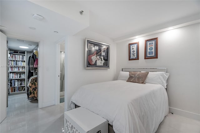 bedroom with a walk in closet and baseboards