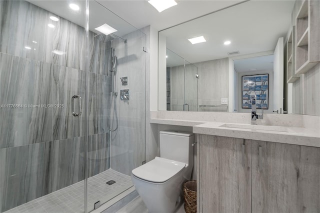 bathroom featuring visible vents, a stall shower, toilet, and vanity