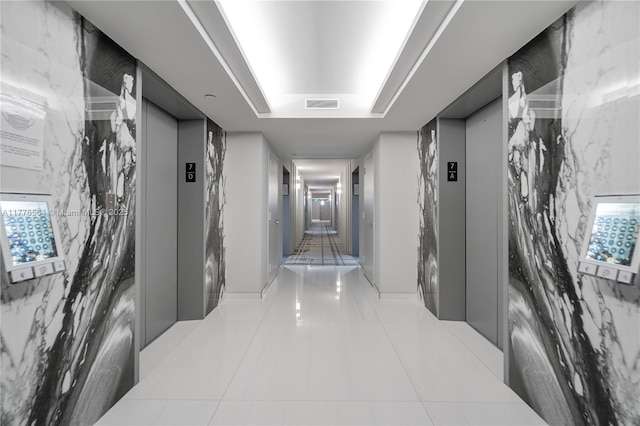 corridor featuring tile patterned flooring, visible vents, and elevator