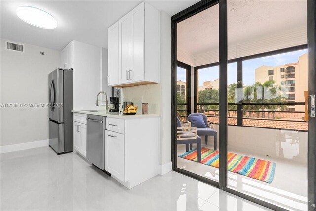 7153 Promenade Dr Unit 302, Boca Raton, FL 33433 - kitchen featuring stainless steel appliances, light countertops, white cabinetry, and light tile patterned floors