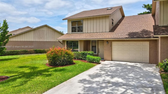 traditional-style house featuring a front lawn, a shingled roof, driveway, and an attached garage
