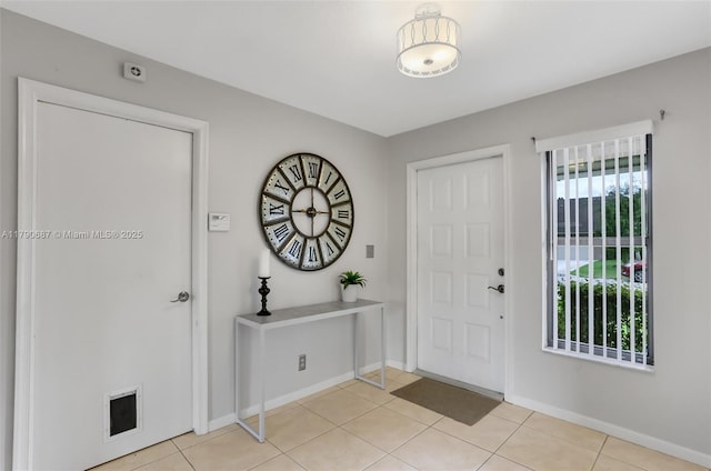 foyer with baseboards and light tile patterned flooring