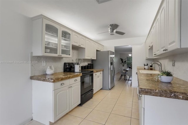 kitchen featuring glass insert cabinets, stainless steel refrigerator with ice dispenser, backsplash, a sink, and black range with electric cooktop