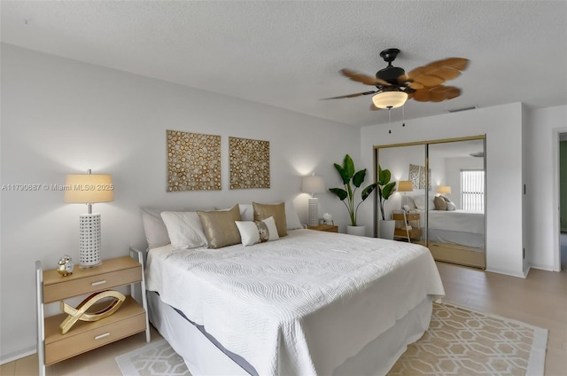 bedroom featuring ceiling fan, a textured ceiling, and a closet