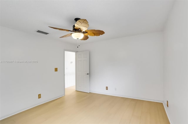 empty room featuring baseboards, visible vents, a ceiling fan, and light wood finished floors